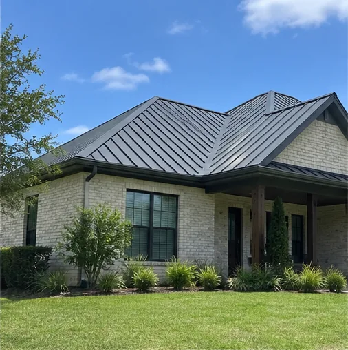 Brick home with a dark standing seam metal roof and a clean green lawn