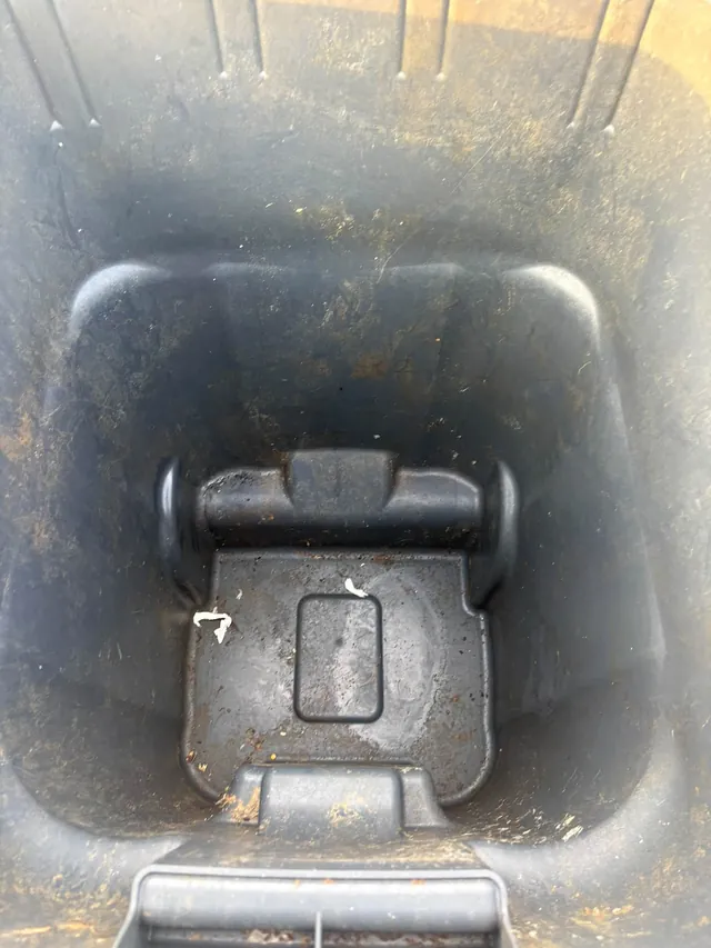 Trash can interior with built-up dirt