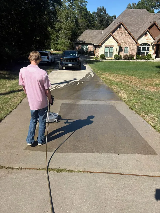 Concrete driveway half cleaned during a wash
