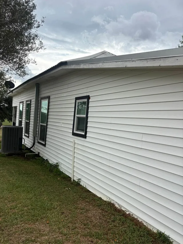 White house siding and metal roof after washing
