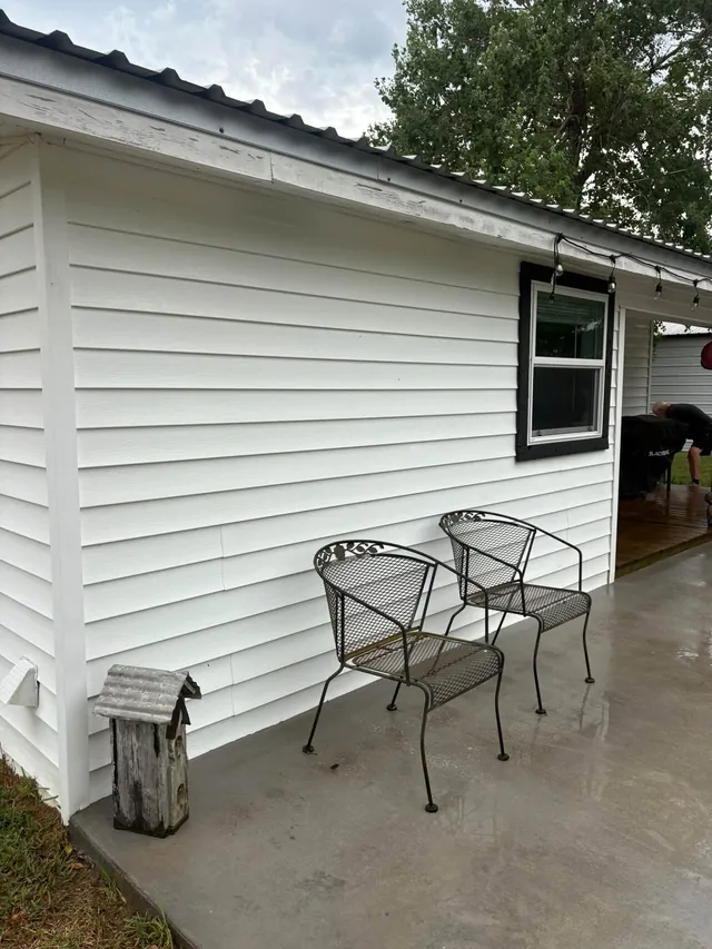White vinyl-sided house and porch after washing