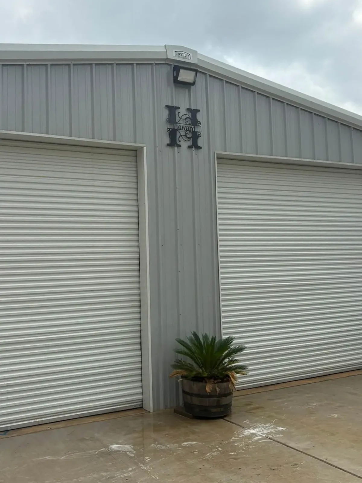 The same metal shop after washing, with clean gray siding