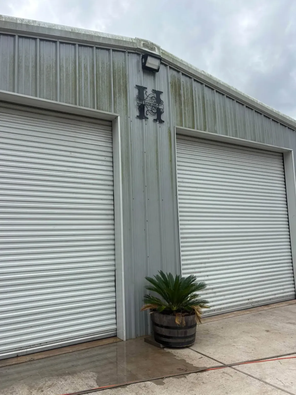 Metal shop with green algae streaks on the siding before washing